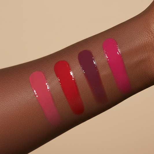 Four pigmented vegan liquid blush swatches on a dark skin arm against a beige background