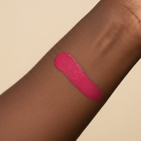 Hot Pink vegan liquid blush swatch on a person's arm against a beige background