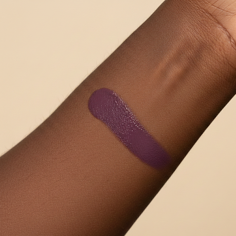 Purple vegan liquid blush swatch on a person's arm with a beige backgroud