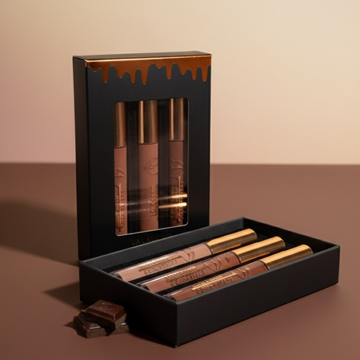 Set of 3 brown vegan lip glosses in a black box on a brown background